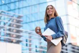 blonde-young-woman-smiling-portrait-holding-laptop-coffee-wearing-blue-gentle-shirt-modern.jpg